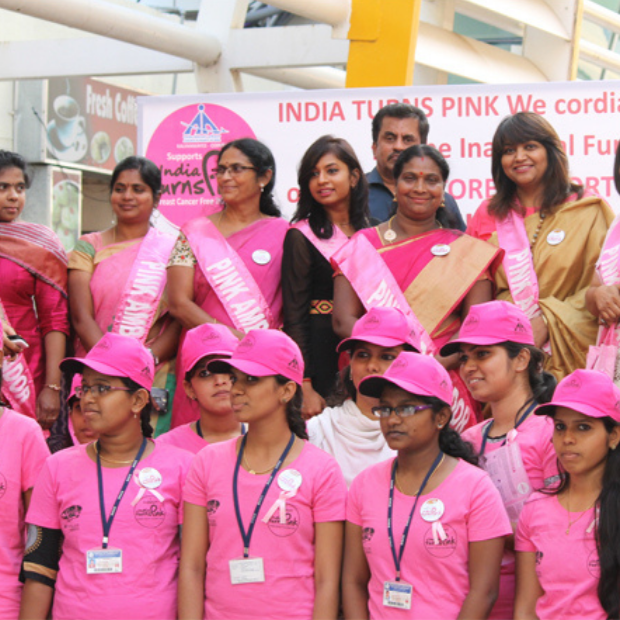 Volunteers running an Airport Turns Pink awareness desk for travellers