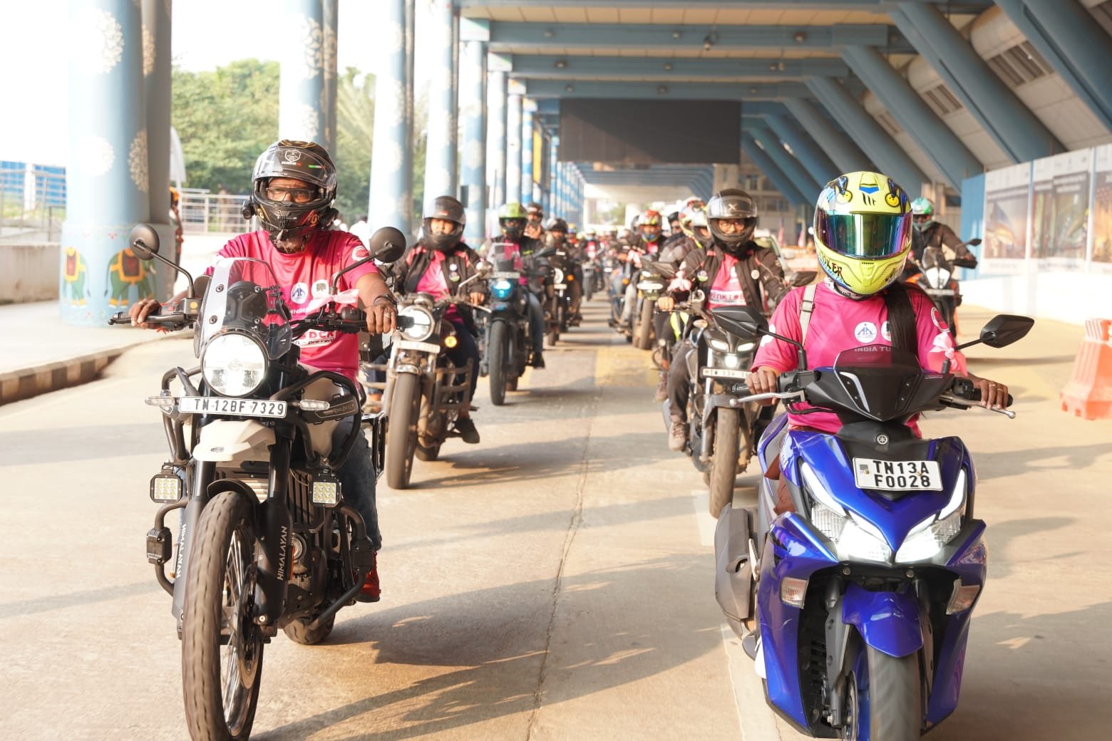 Riders assembled with pink flags for an awareness bike rally