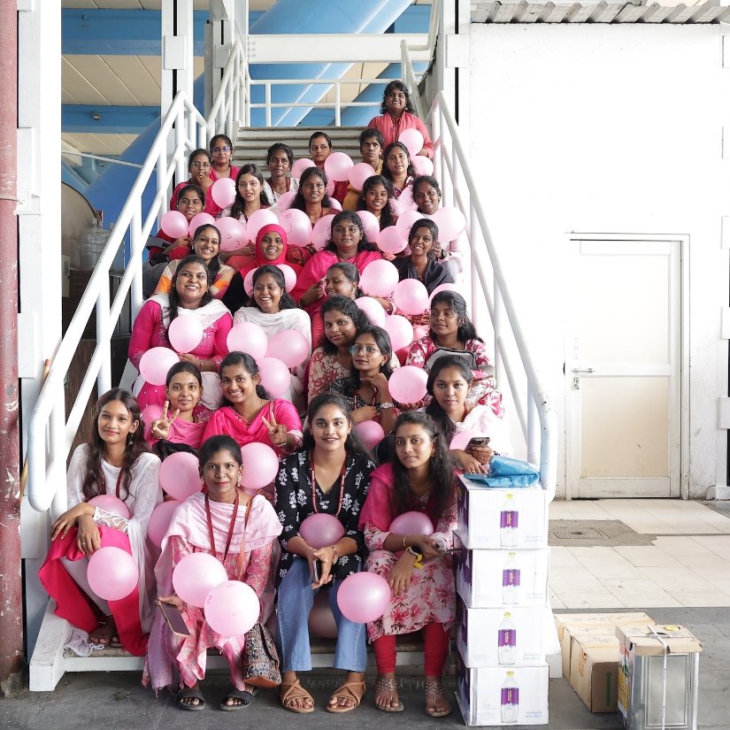 Students and volunteers holding pink balloons at a campus awareness event