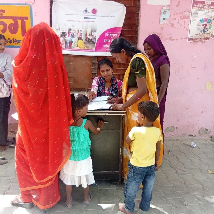 Women registering at a rural awareness camp registration table